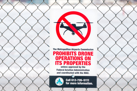 MINNEAPOLIS, MN/USA - JANUARY 14, 2017: Sign attached to chain link fence prohibiting drones at airport in the United States.のeditorial素材