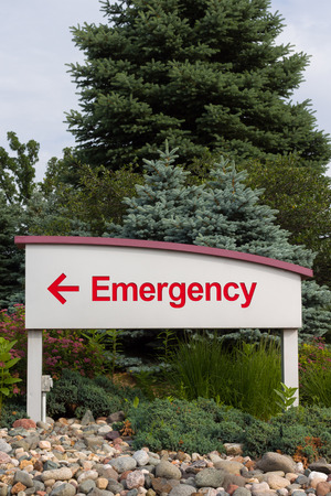 Red emergency sign and arrow pointing left on sign with white background.の写真素材