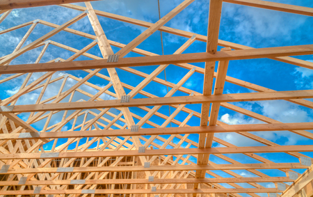 New home under construction looking upward to bright blue sky.の写真素材