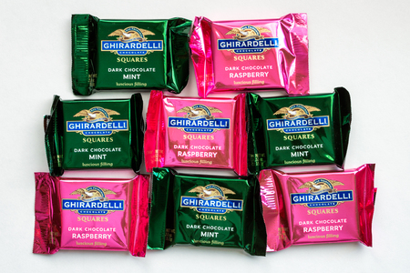 ST. PAUL, MN/USA - FEBRUARY 21, 2019: Collection of small Ghirardelli Chocolate Squares and trademark logo. The Ghirardelli Chocolate Company is a United States candy company.のeditorial素材