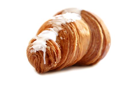croissant with sugar glaze close-up on a white backgroundの写真素材