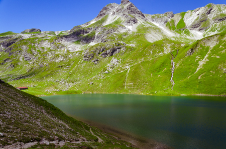 Alp lake with a hut on the way between the Nebelhorn and the Giebelhaus.の写真素材