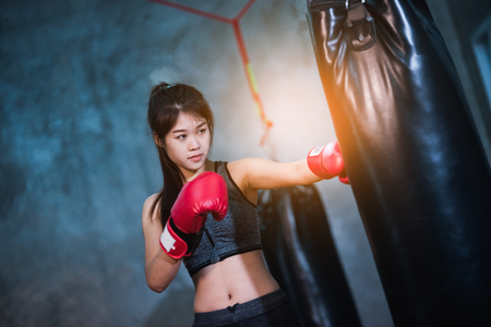 sexy asia girl punching boxing bagの写真素材