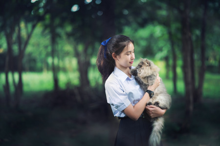 asia girl wearing uniform playing with a little catの写真素材