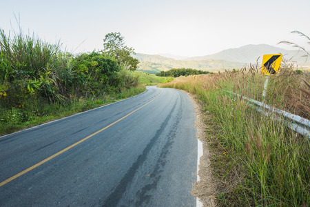Empty road with sunlight on mountain in the morningの写真素材