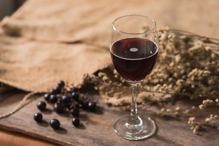 Glass of red wine and grapesの写真素材