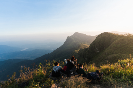 tourists with taking photo of a valley from top of a mountainの写真素材