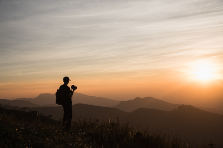 Photographers Silhouettes On Cliff Against Colorful Twilight Skyの写真素材