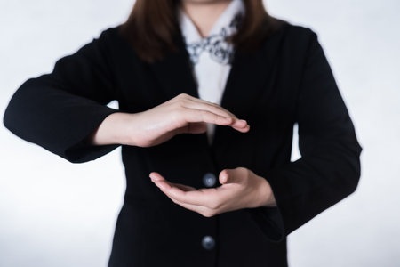 Businesswomen standing posture show hand on over gray backgroundの写真素材