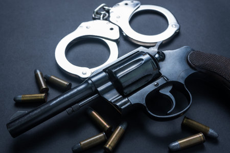 Gun with ammunition and shackle on black background