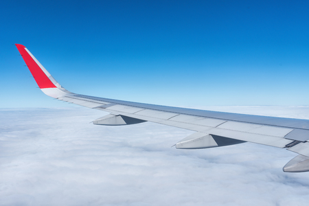 Wing of an airplane on the blue sky in the morningの写真素材