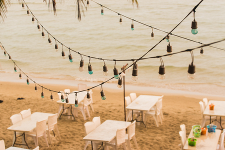 Decorative vintage lightbulbs on beach backgroundの写真素材