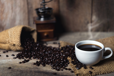 Cup of coffee and coffee beans on tableの写真素材