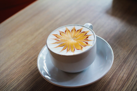 Latte art coffee cup on wood tableの写真素材