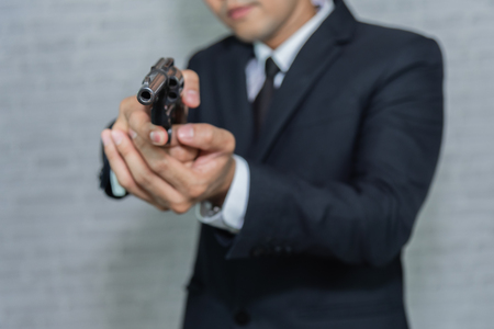 businessman with black suit and gunの写真素材