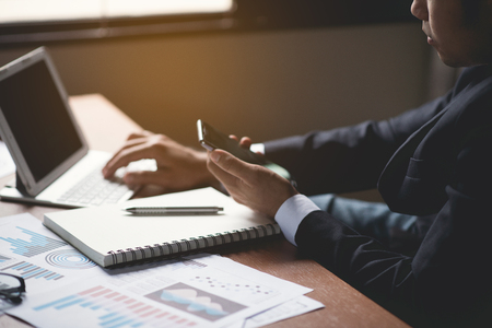 Businessman using mobile and working on desk office businessの写真素材