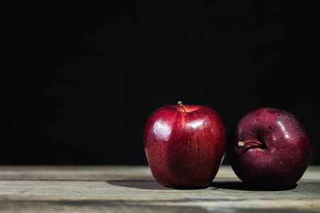 red apple on wood table on dark backgroundの写真素材