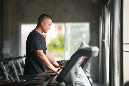 sport man exercise using walking on the treadmill at the gymの写真素材