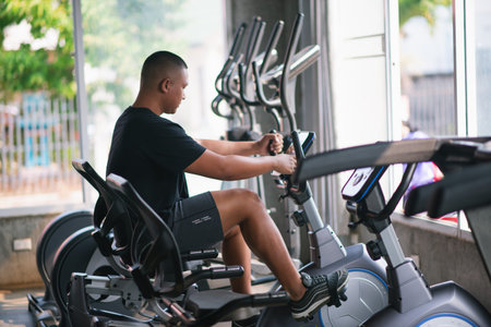 sport man using exercise bike at the gym