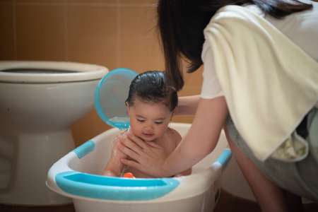 cute asian baby girl take a shower with her mom