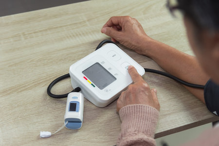 old woman with tonometer checking blood pressure level