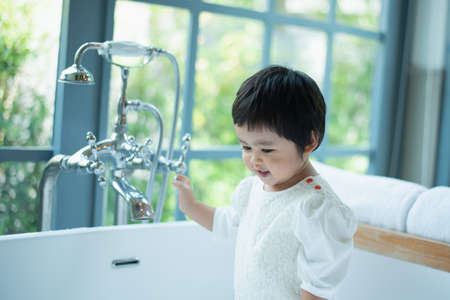 cute baby taking a shower in bathtubの写真素材
