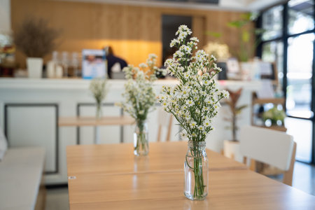 close up of white flowers on wood table in the cafe