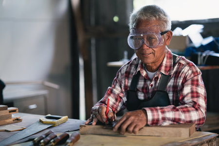 Carpenter working on wood in carpentry shop. the man works in a carpentry shopの写真素材