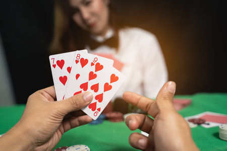 Women dealer or croupier shuffles poker cards in a casino on the background of a table, poker game...