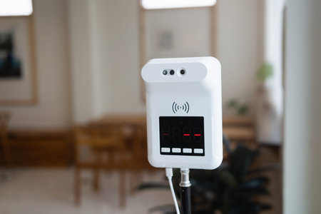 digital thermometer for measuring body temperature by placing a hand over the sensor in a cafe