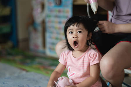 cute baby girl eating cookies in the houseの写真素材