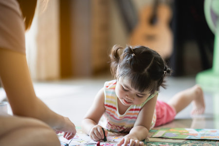 cute baby girl painting with her mother at the houseの写真素材