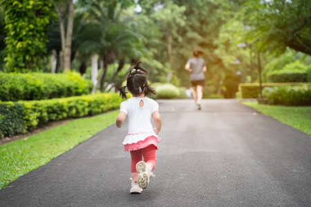 cute baby running with her mother in the garden, family happy conceptの写真素材