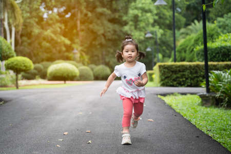 cute girl running at the gardenの写真素材
