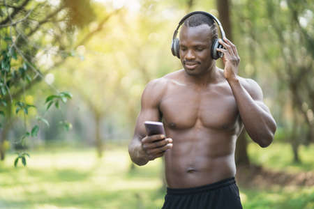 african man running and smiling at park in morning. Sport man exercise in the park. Sport conceptの写真素材