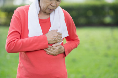 Senior asian woman suffer from exercise pain. Senior woman having heart attack after exercise at...