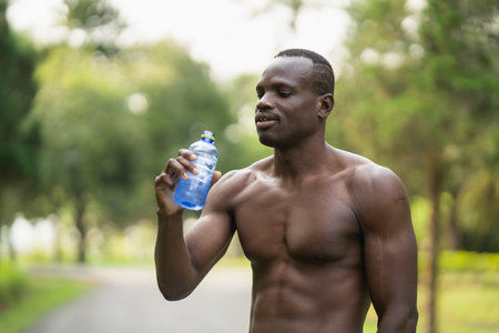 Attractive African sport man tired and thirsty after running workout drinking water. Sport man conceptの写真素材
