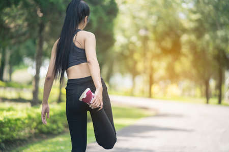 Sport women drinking water after running in the gardenの写真素材