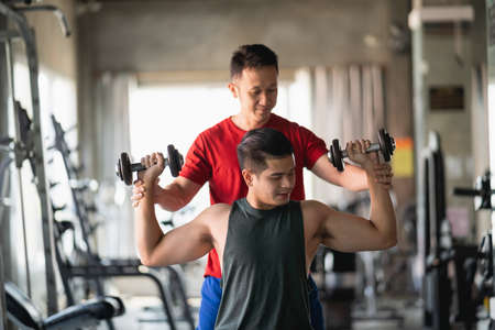Asian fit sport man working out in weights room at the gym. Sport man conceptの写真素材