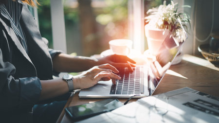 Woman holding credit card and using laptop computer. Businesswoman working at home. Online shopping,...