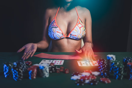 Woman wearing bikini dealer or croupier shuffles poker cards in a casino on the background of a...