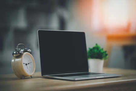 Workspace with laptop and clock on the table in co-working space. Conceptual workspace,Empty space desk white with on Laptop computer screen.の写真素材
