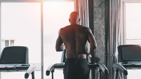 African sport man running on treadmill in fitness club. Cardio workout. Healthy lifestyle, guy training in gym. Sport running conceptの写真素材