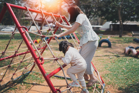 young asian mother playing with her baby on the playground. Mom and daughter. Cute baby daughter playing with mom happy funny family conceptの写真素材