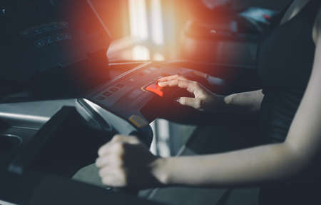 Asian sport woman running on treadmill in fitness club. Cardio workout. Healthy lifestyle, guy training in gym. Sport running conceptの写真素材