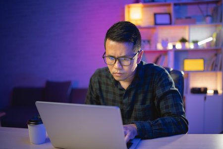 freelance man working on laptop At home at night. Man developer programmer, data engineer, thinking,...