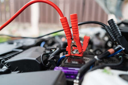 Car battery jump cable for car battery is dead. car battery charger The car battery is exhausted. Car service jumper battery transportation concept.の写真素材