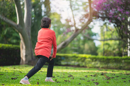 Senior asian woman body warming before exercising. Old woman stretching before jogging in garden, Sport athlete running concept.の写真素材