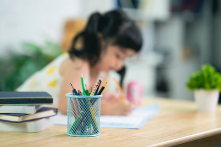 close up pencil holder and cute little child wearing white headphone painting with colorful paints. Asian girl using wood color drawing color.Baby artist activity lifestyle concept.の写真素材