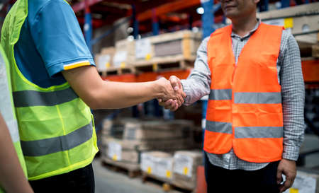 Group of industrial warehouse asian worker in safety suite hand stack celebrate successful or deal commitment. Logistics , supply chain and warehouse business.Teamwork unity under view concept.の写真素材